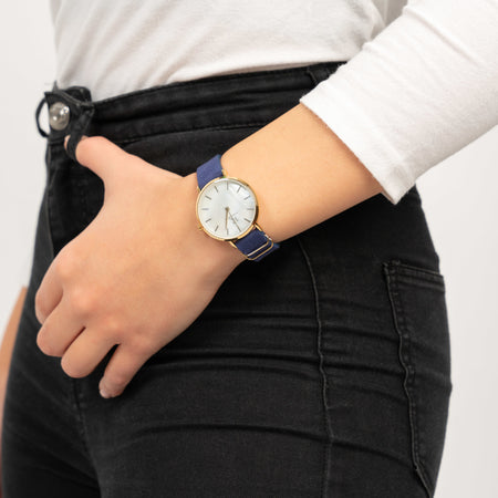 Frau trägt die Victor De Rossa Armbanduhr „Sedurre 801“ mit blauem Wildlederarmband, Perlmutt Zifferblatt und goldenem Gehäuse