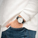 Mann trägt die Victor De Rossa Armbanduhr „Onesto 001“ mit schwarzem Lederarmband, weißem Zifferblatt und silbernem Gehäuse