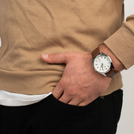 Mann trägt die Victor De Rossa Armbanduhr „Onesto 071“ mit braunem Lederarmband, weißem Zifferblatt und silbernem Gehäuse