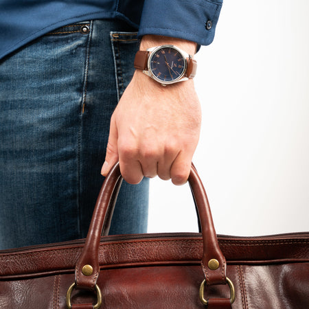 Mann trägt die Victor De Rossa Armbanduhr „Onesto 141“ mit braunem Lederarmband, blauem Zifferblatt und silbernem Gehäuse