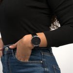 Frau trägt die Victor De Rossa Armbanduhr „Aperto 551“ mit schwarzem Lederarmband, schwarzem Zifferblatt und silbernem Gehäuse