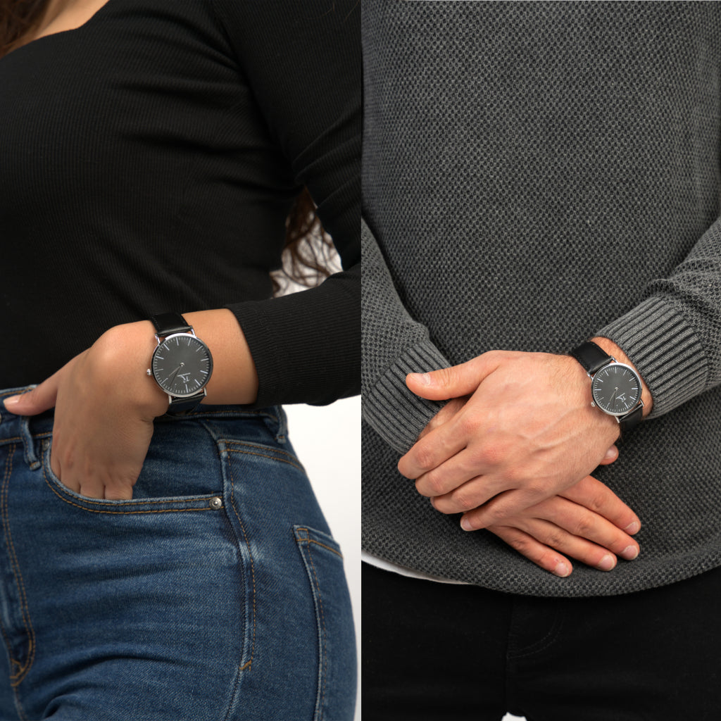 Mann & Frau tragen die Victor De Rossa Armbanduhr „Aperto 551“ mit schwarzem Lederarmband, schwarzem Zifferblatt und silbernem Gehäuse